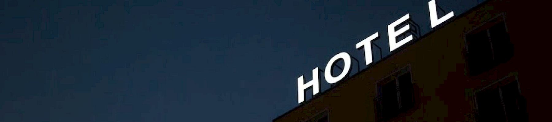A hotel building with an illuminated sign reading 