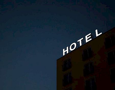 A hotel building with an illuminated sign reading 